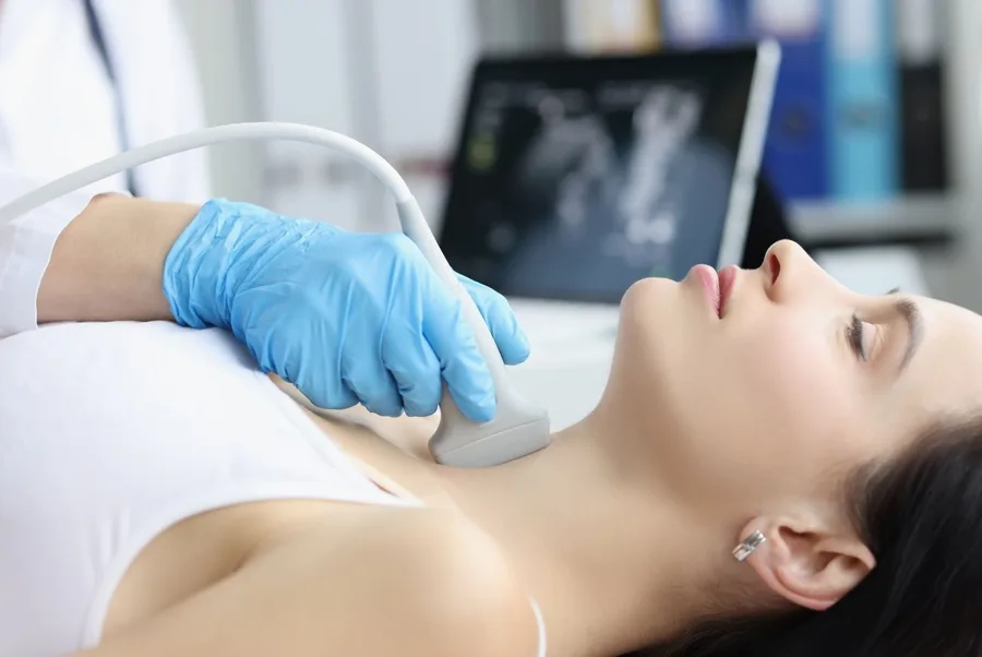Physician examining a patient's neck (stock image)